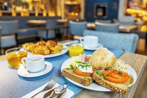 A breakfast setting with toast, eggs, and juice on a table.