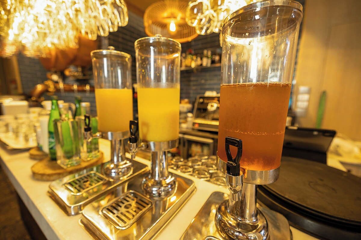 A bar with three taps dispensing drinks.