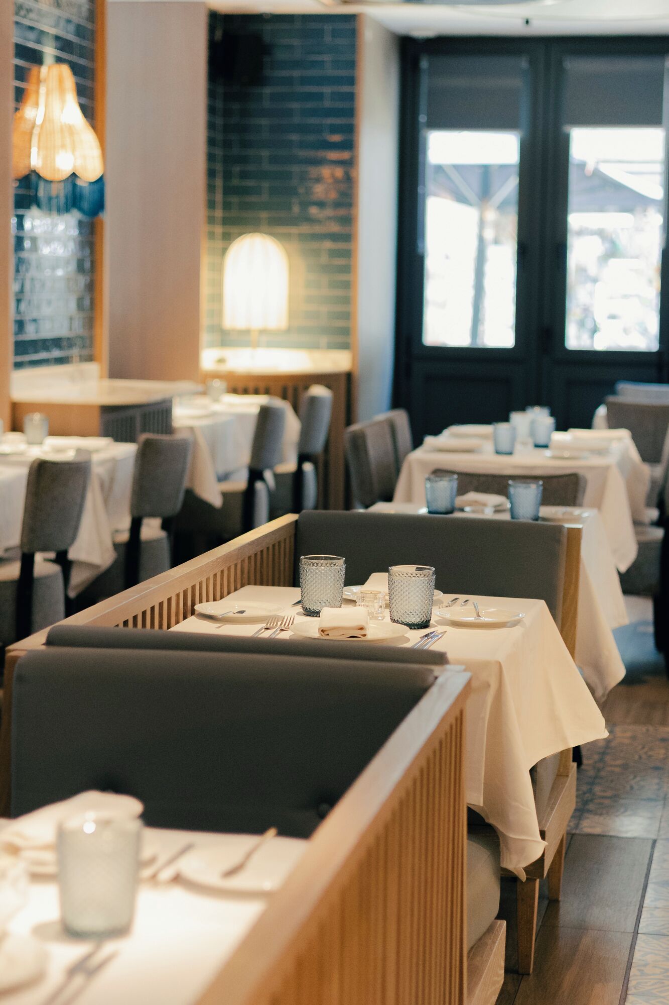 Ein Restaurant mit Sitzecken, Tischen und einer Ziegelwand.