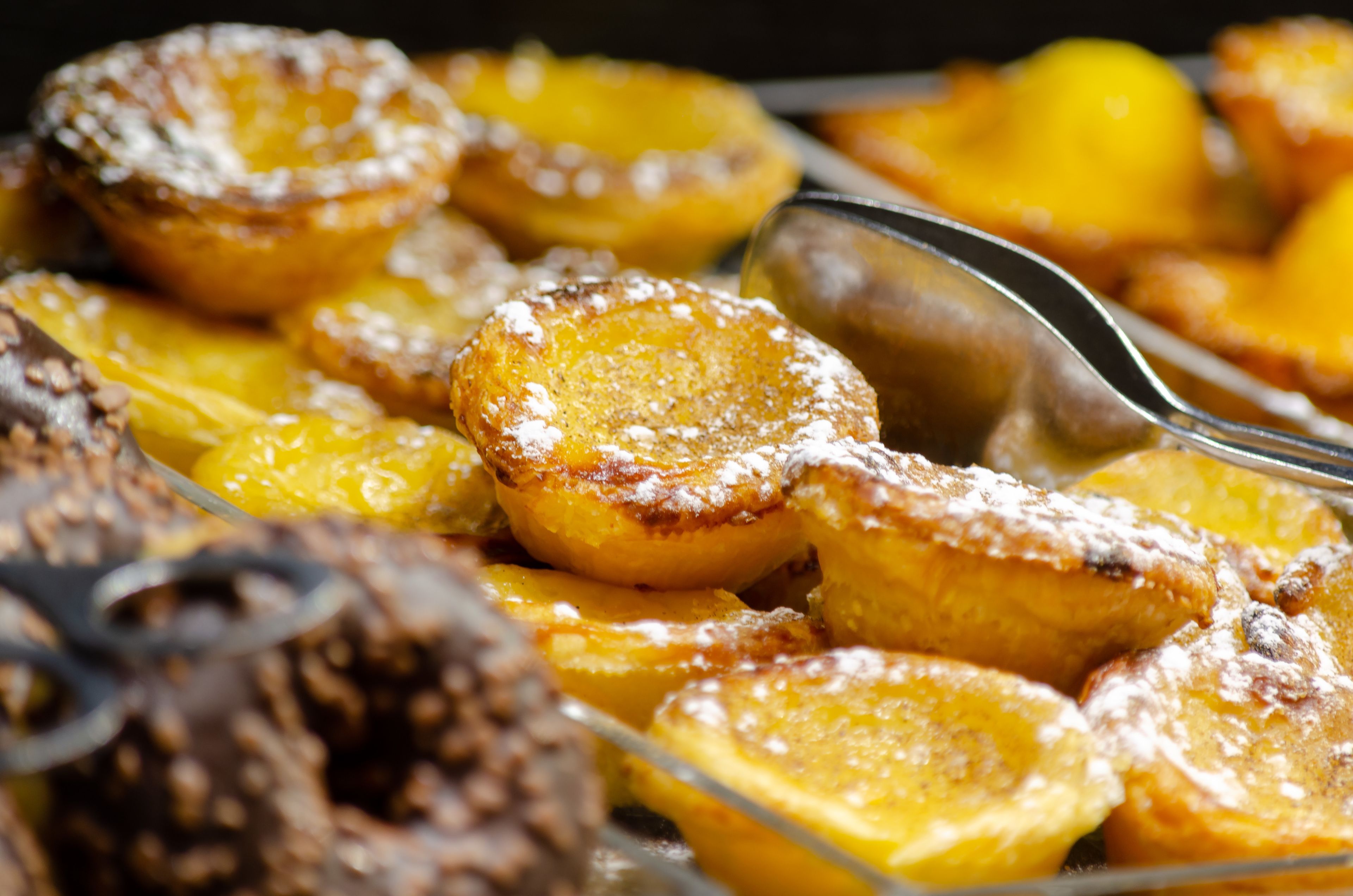 Primer plano de pasteles horneados, posiblemente tartas o pasteles, con una corteza dorada y una capa de azúcar glas.