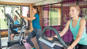 A gym with stationary bikes and a person using a treadmill.