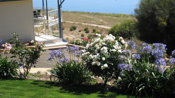 A coastal house with a patio, outdoor seating, and a view of the sea. - Lindsays of Kangaroo Island (Penneshaw)