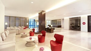 Um lobby espaçoso com balcão de recepção, área de estar e design moderno.