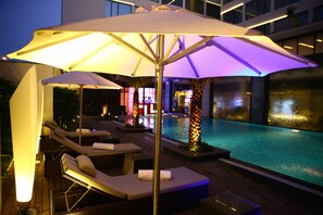 Een buitenzwembad, parasols voor strand/zwembad