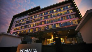 Um hotel com vários andares e um letreiro grande com a palavra 'VIVANTA' na entrada.