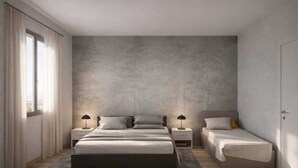 A bedroom with a large bed, two bedside tables with lamps, a smaller bed, and a wardrobe.