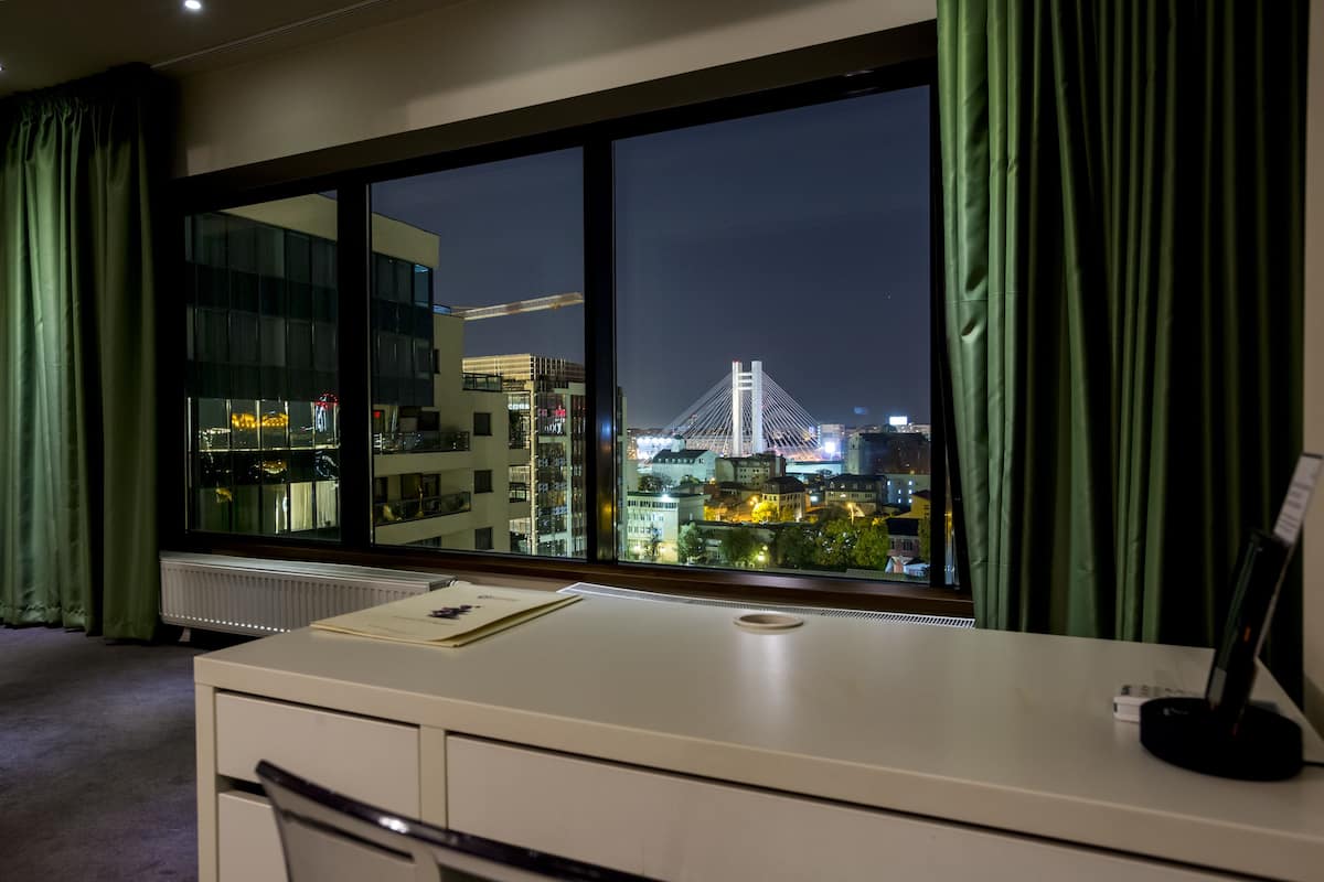 A room with a large window, a desk, and a chair.
