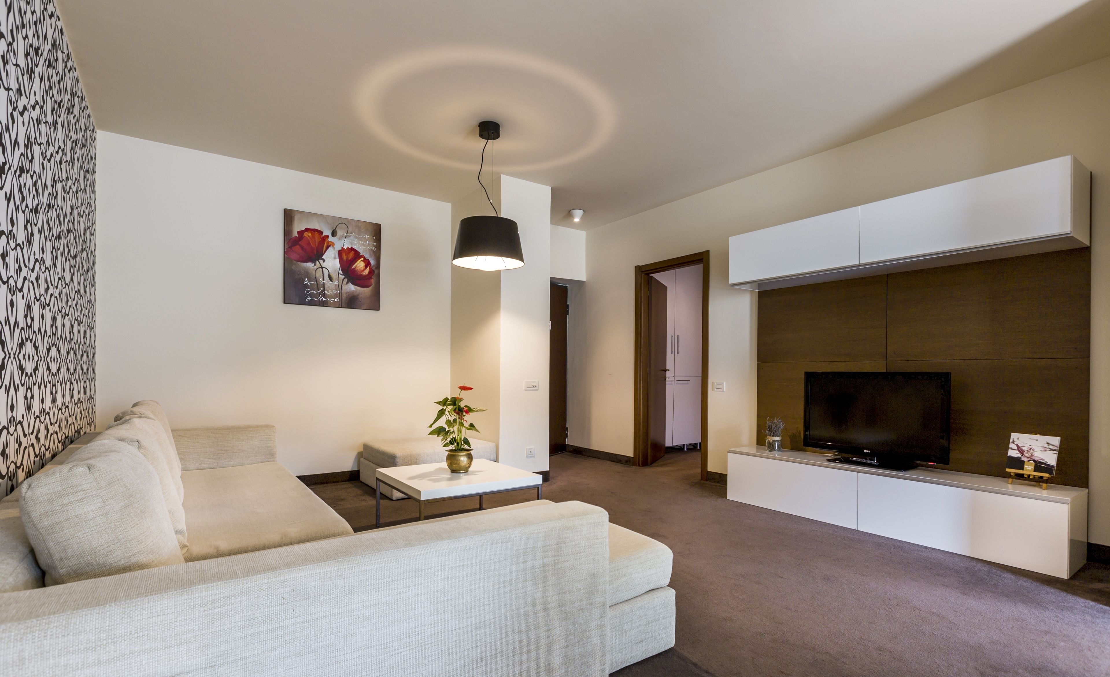 Ein modernes Wohnzimmer mit einer Couch, einem Couchtisch, einem Fernseher und einem Kamin.