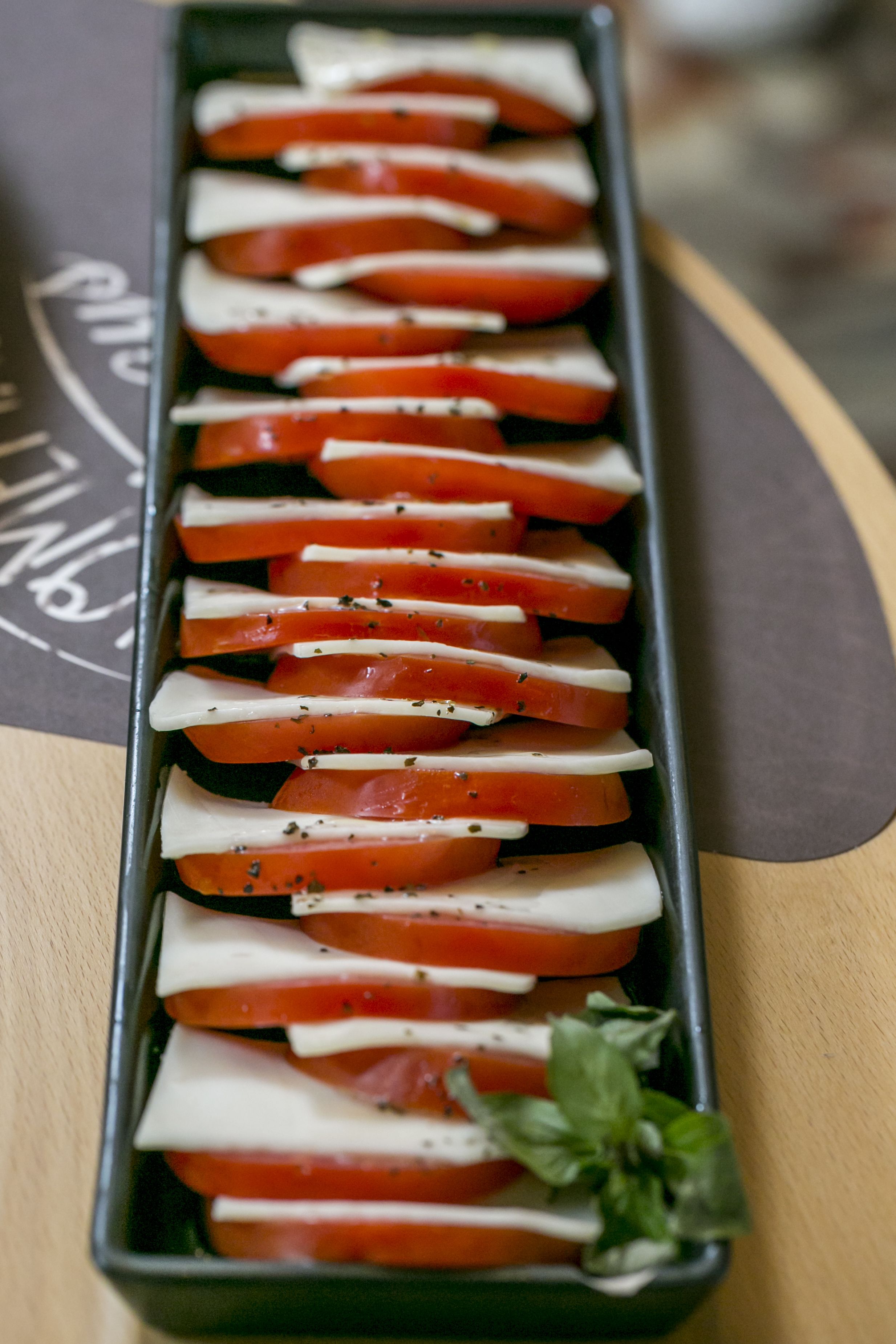 Une assiette de tomates et de fromage coupés en tranches.