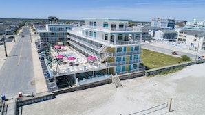 A multi-story hotel with balconies, a pool area, and a beach view. - Paradise Oceanfront Resort (Wildwood Crest)