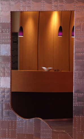 A bathroom with wooden cabinets, a sink, and a mirror. - Hotel Tati (Lugo)