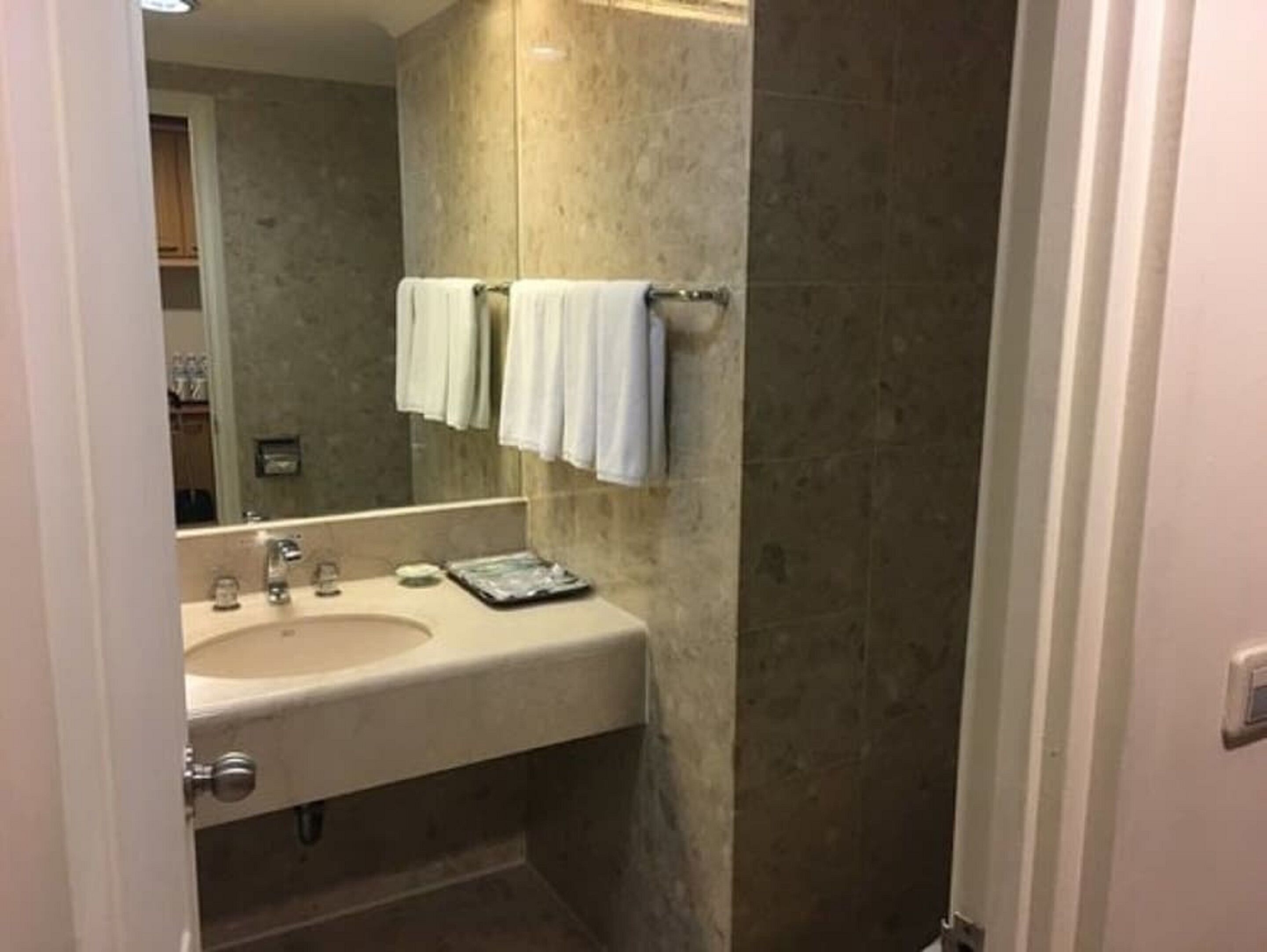Une salle de bain équipée d’un lavabo, d’un miroir et d’un porte-serviettes.
