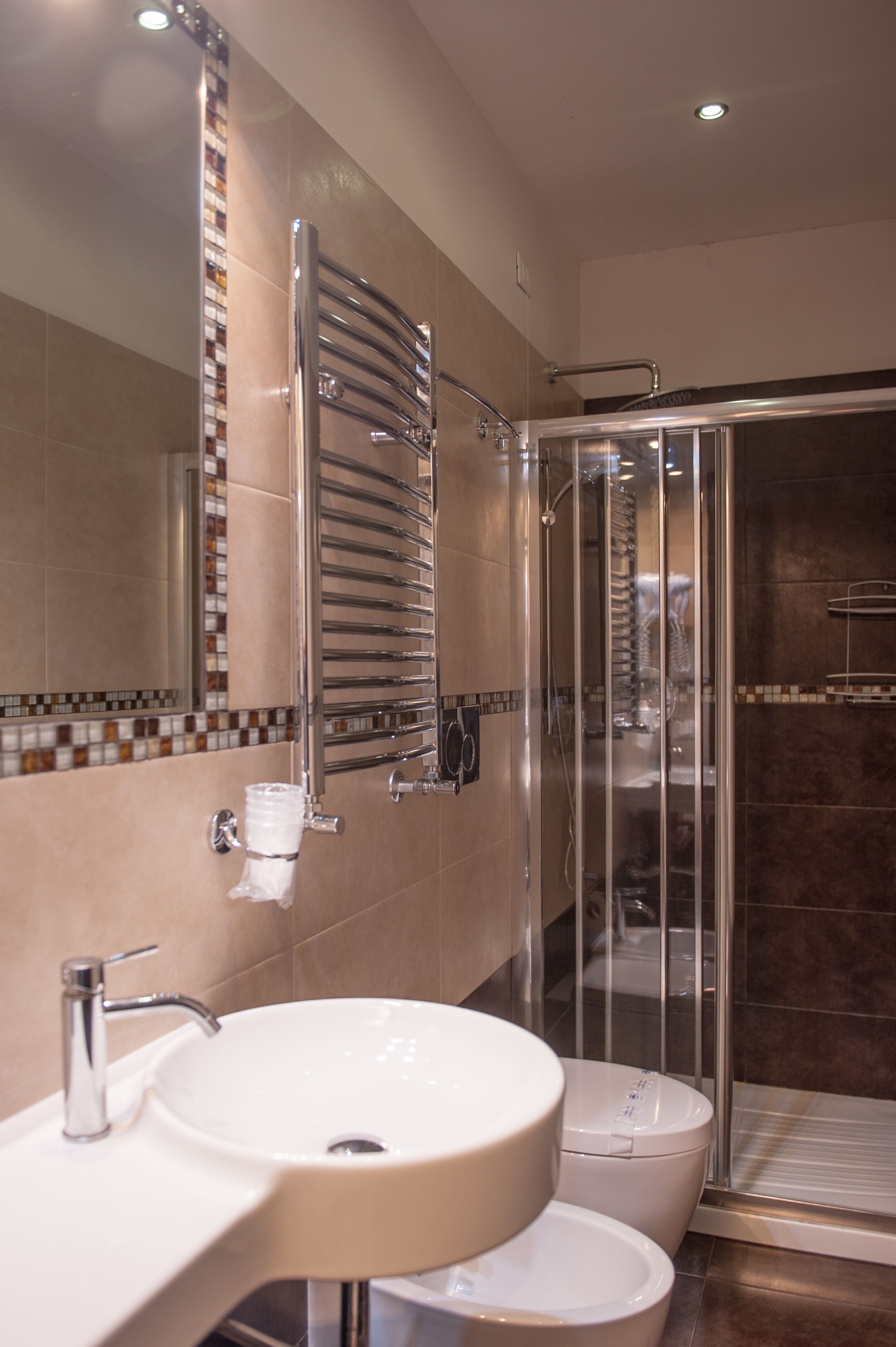 A modern bathroom with a sink, toilet, and glass shower enclosure.