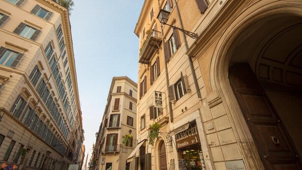 A street view with historic buildings, a shop with a sign reading "Tabacco Rivendetta," and a clear blue sky. - Rome King Suite (Rome)
