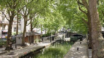 Un canal bordeado de árboles y un puente.