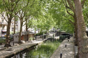 A canal lined with trees and a bridge.