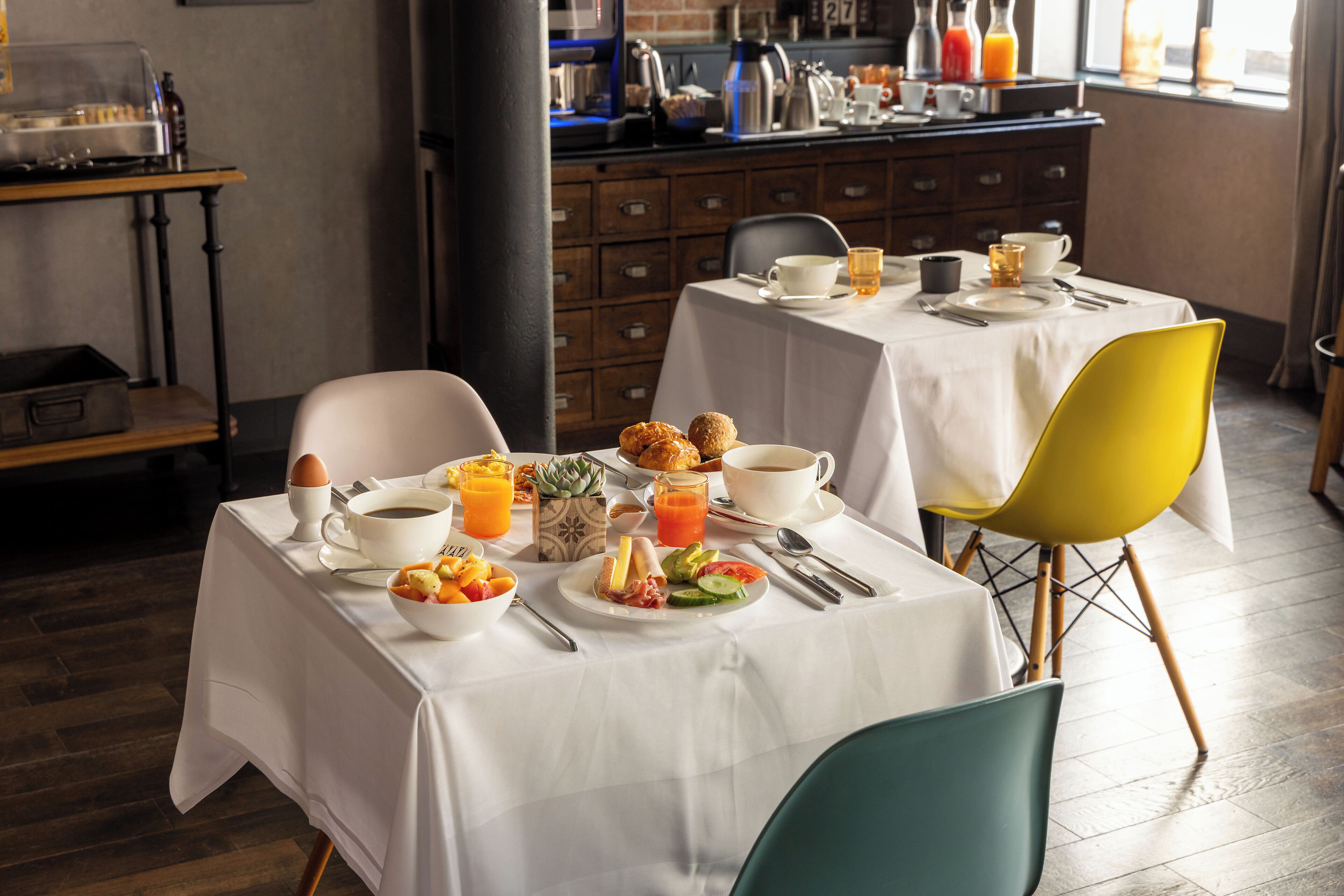 A breakfast setup with tables, chairs, and a variety of breakfast items.