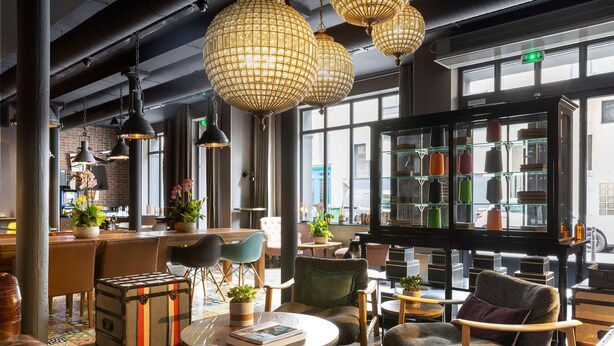 Uma área de estar moderna com assentos de couro, um bar de café e uma exposição de bolsas.