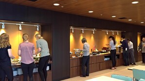 Una hall d'albergo moderna con pannelli in legno e illuminazione a incasso.