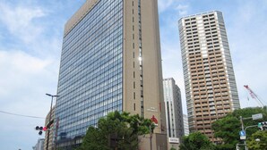 Un edificio moderno con una facciata in vetro e rivestimento marrone.