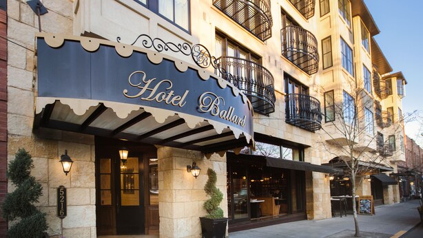 A hotel with a classic facade, large windows, and decorative iron balconies.