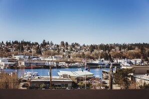 A marina with boats docked, a clear sky, and a residential area in the background. - Hotel Ballard (Seattle)