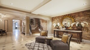 A spacious foyer with a grand staircase, a large mirror, and a decorative console table.