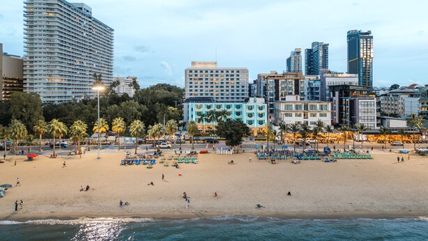 A beachfront hotel with multiple floors, a beach in the foreground, and palm trees. - Wave Hotel Pattaya (Pattaya)