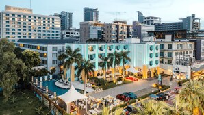 A hotel with a swimming pool, outdoor seating, and a view of the city skyline. - Wave Hotel Pattaya (Pattaya)