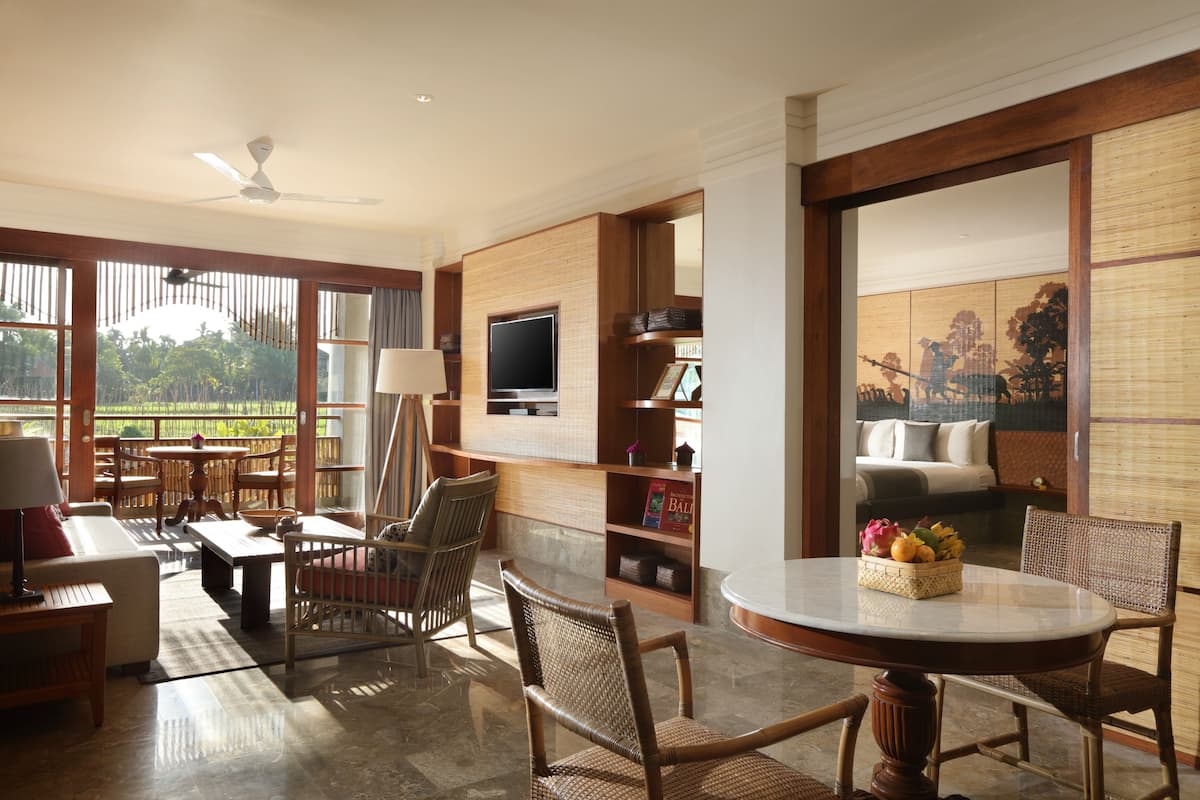 Un amplio espacio de sala con un ventanal grande, un televisor y una mesa de comedor con sillas.