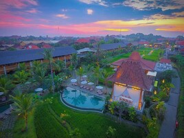 A resort with a swimming pool, lounge areas, and a garden.