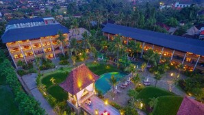 Un resort con varias edificaciones, una piscina y jardines bien cuidados.