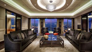 A spacious living room with two sofas, a coffee table, and a large window offering a city view. - Hilton Istanbul Bomonti Hotel & Conference Center (Istanbul)