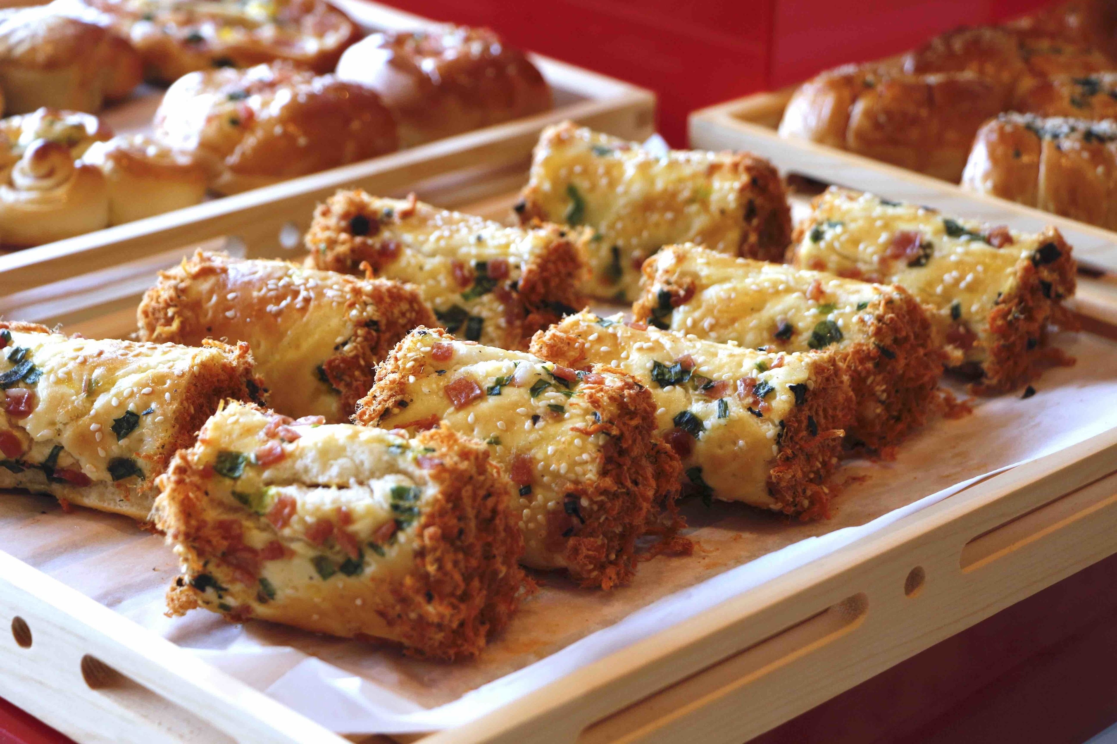 Un plateau de produits de boulangerie, peut-être du pain ou des pâtisseries, avec des herbes et du fromage visibles.