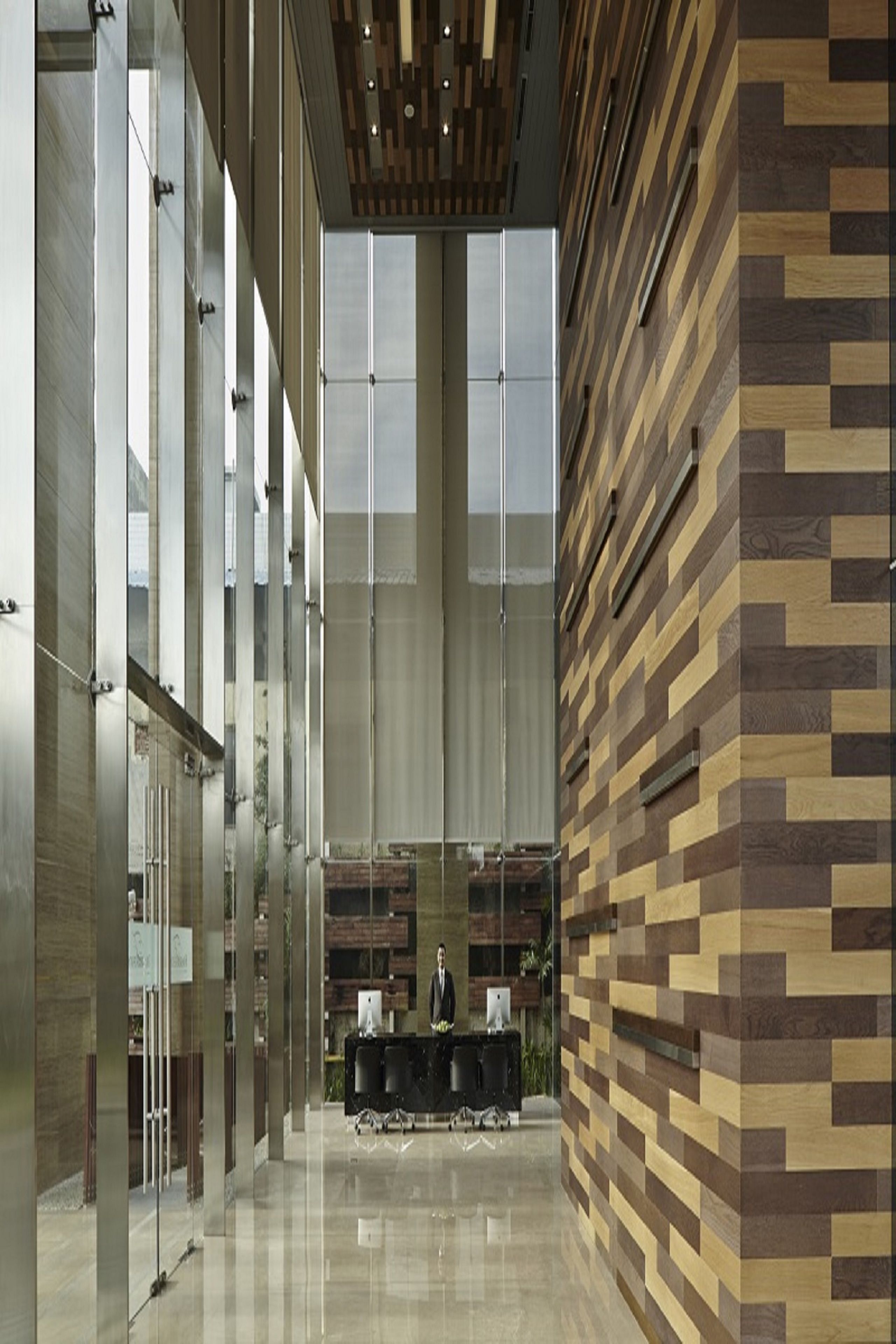 Eine geräumige Lobby mit modernem Design, inklusive einer Rezeption und großen Fenstern.