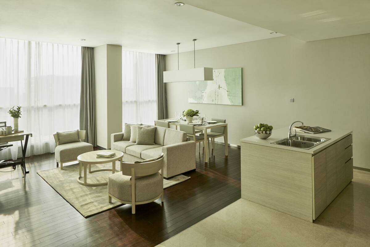 Uma sala de estar moderna com sofá, mesa de centro e área de jantar.