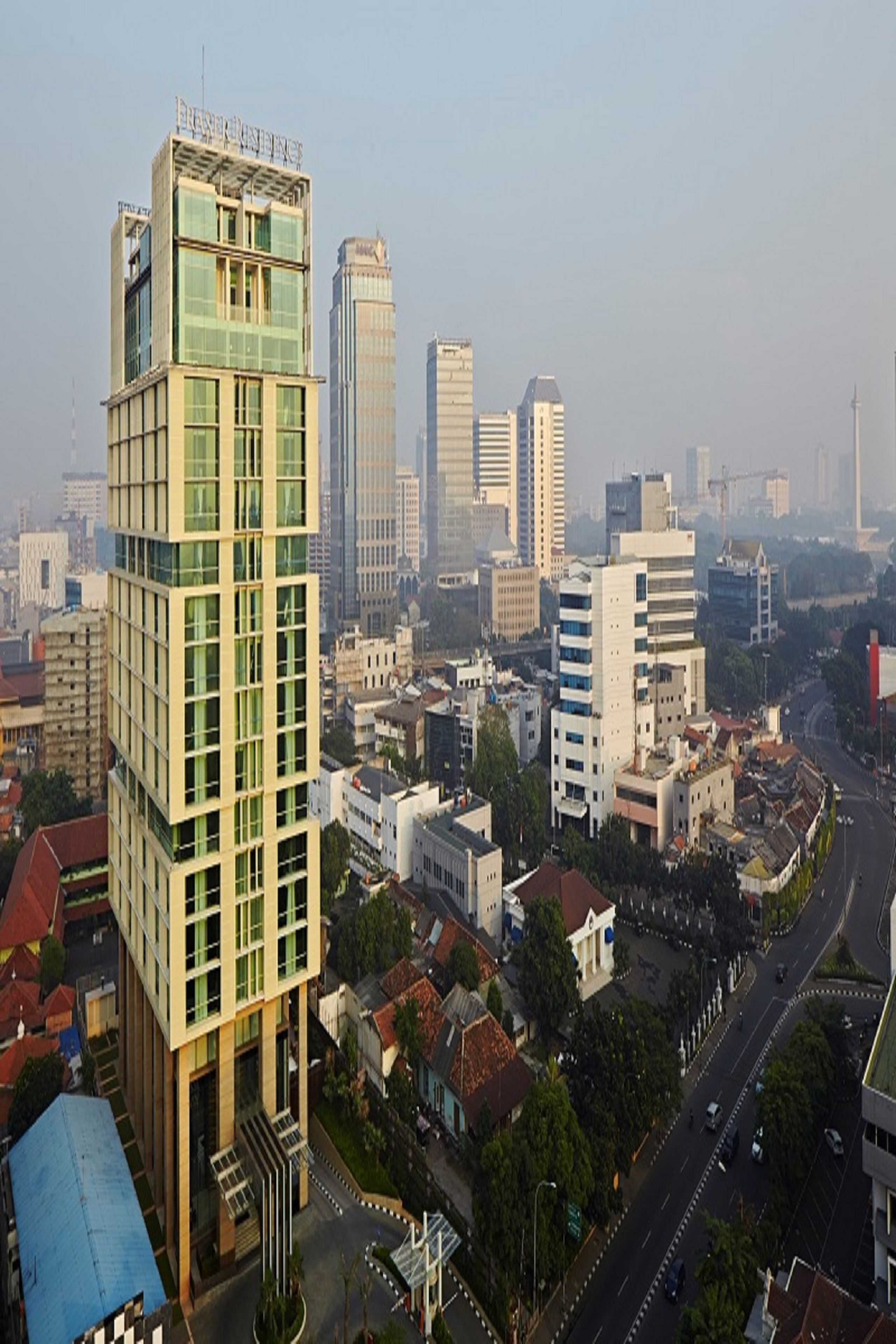 A modern high-rise building with a glass facade and a prominent entrance.