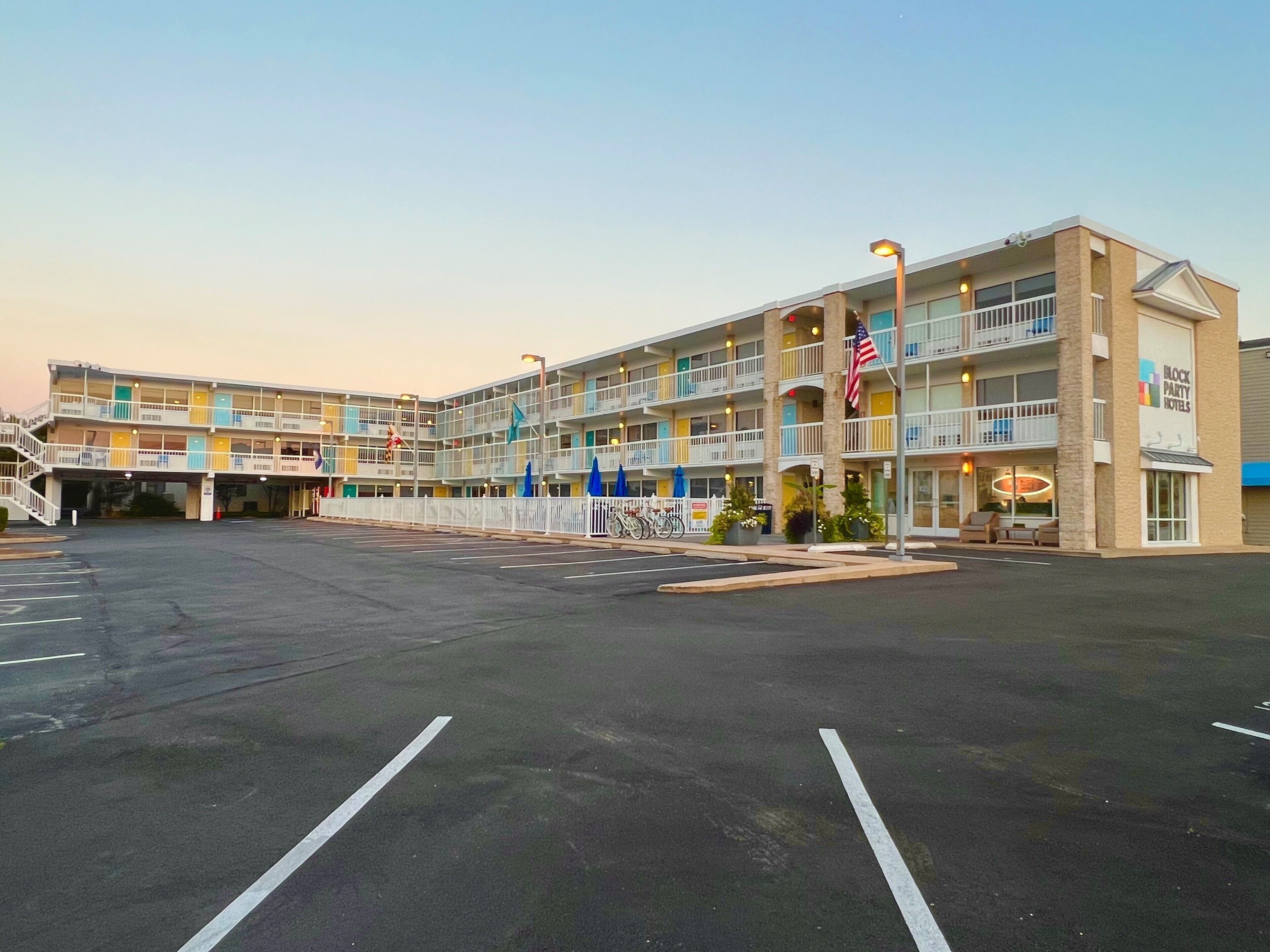 A multi-story hotel with a parking lot in front.