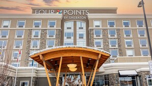 Un hotel con un cartel que dice "FOUR POINTS BY SHERATON" y una entrada a "Lounge & Grill".