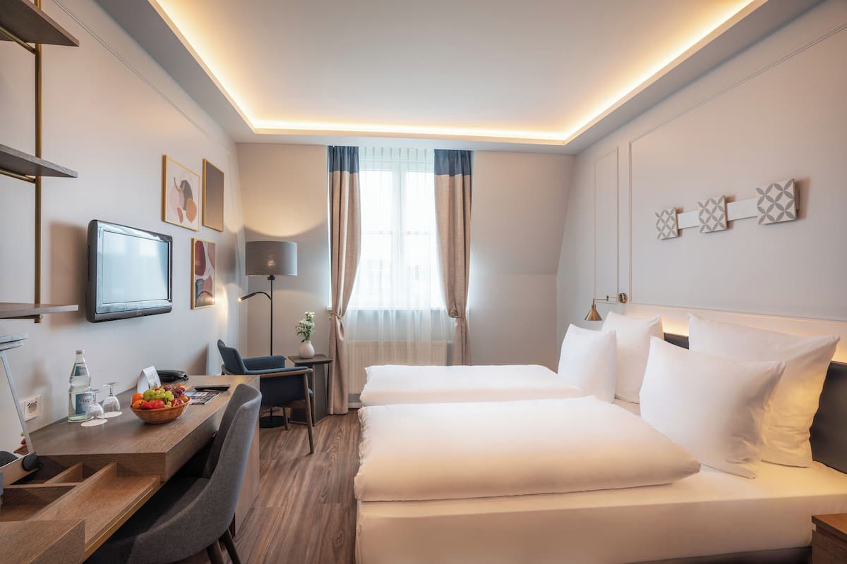 Een hotelkamer met een bed, nachtkastje, bureau, stoel en een televisie.