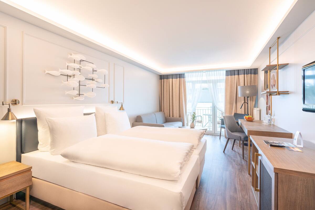 Een moderne hotelkamer met een groot bed, een bureau en een zithoek.