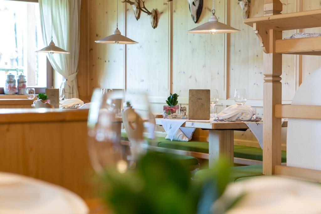 Un interior de madera con comedor, luces colgantes y una mesa con una planta.