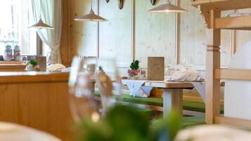 Un interior de madera con comedor, luces colgantes y una mesa con una planta.