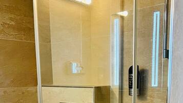 Ein modernes Badezimmer mit einer Glasdusche, einer Toilette und einem Handtuchhalter.