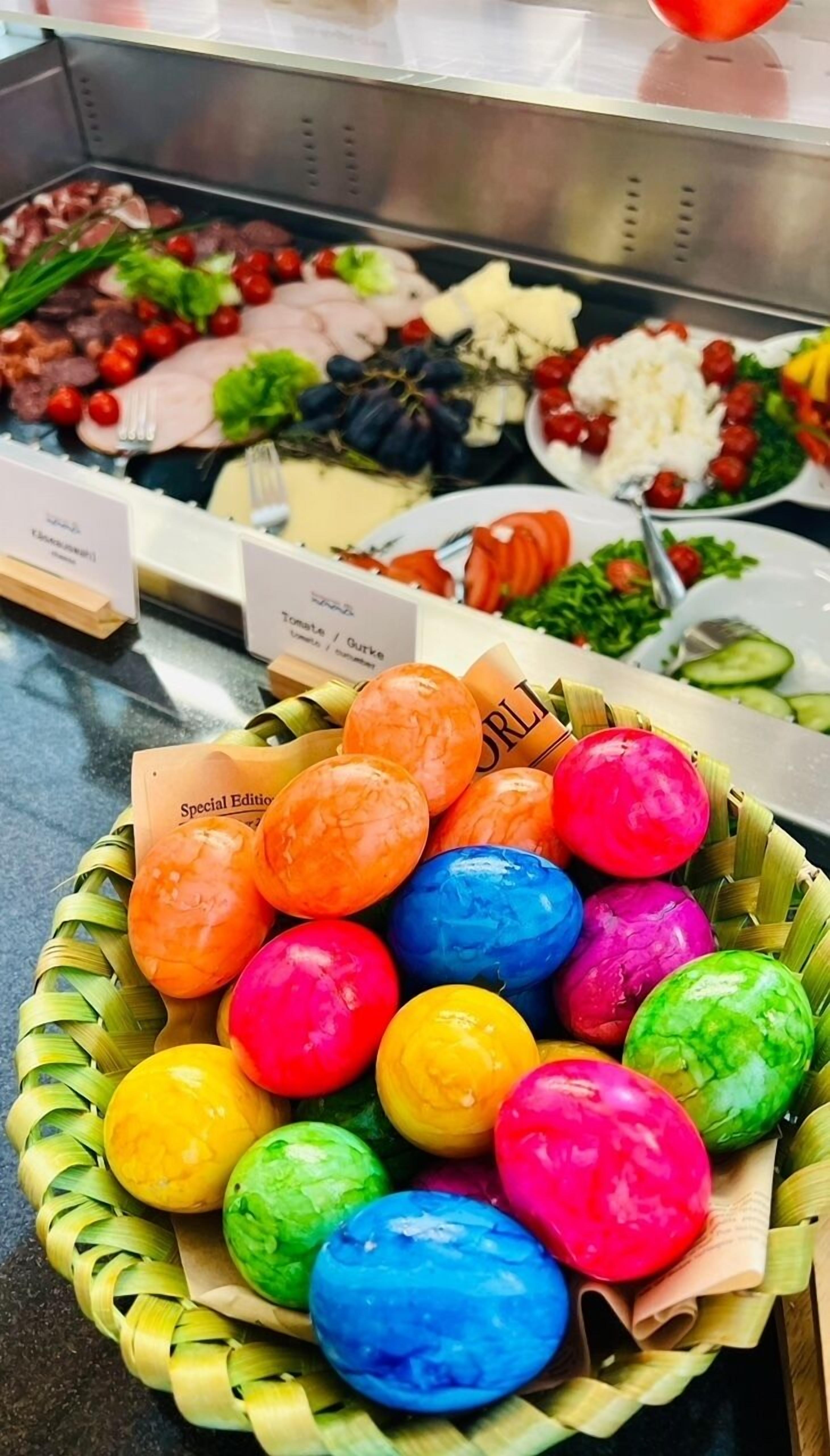 A buffet with various dishes including a basket of colorful, steamed eggs.