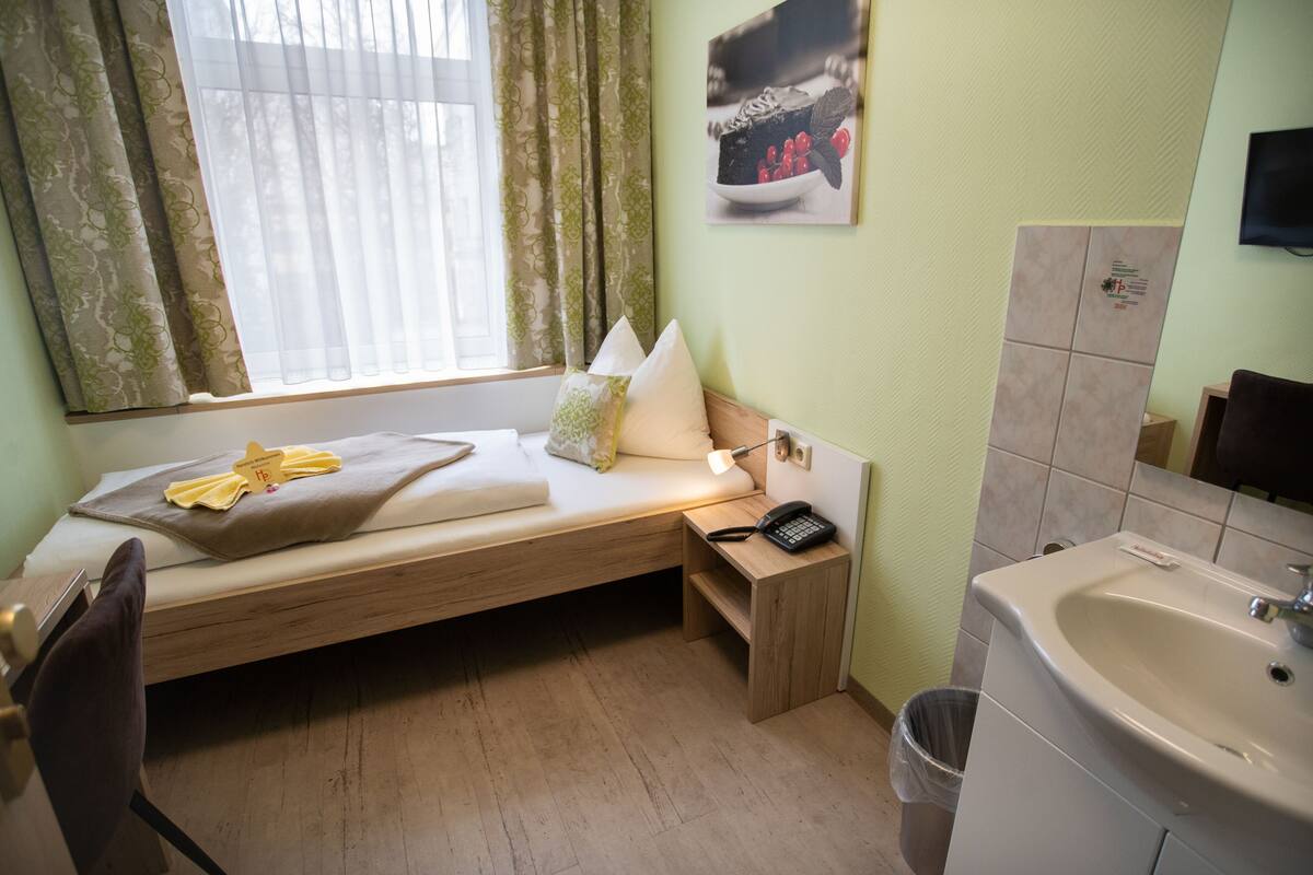 Quarto solteiro, banheiro compartilhado (shared WC) | Roupas de cama premium, escrivaninha, Wi-Fi (sobretaxa), roupa de cama