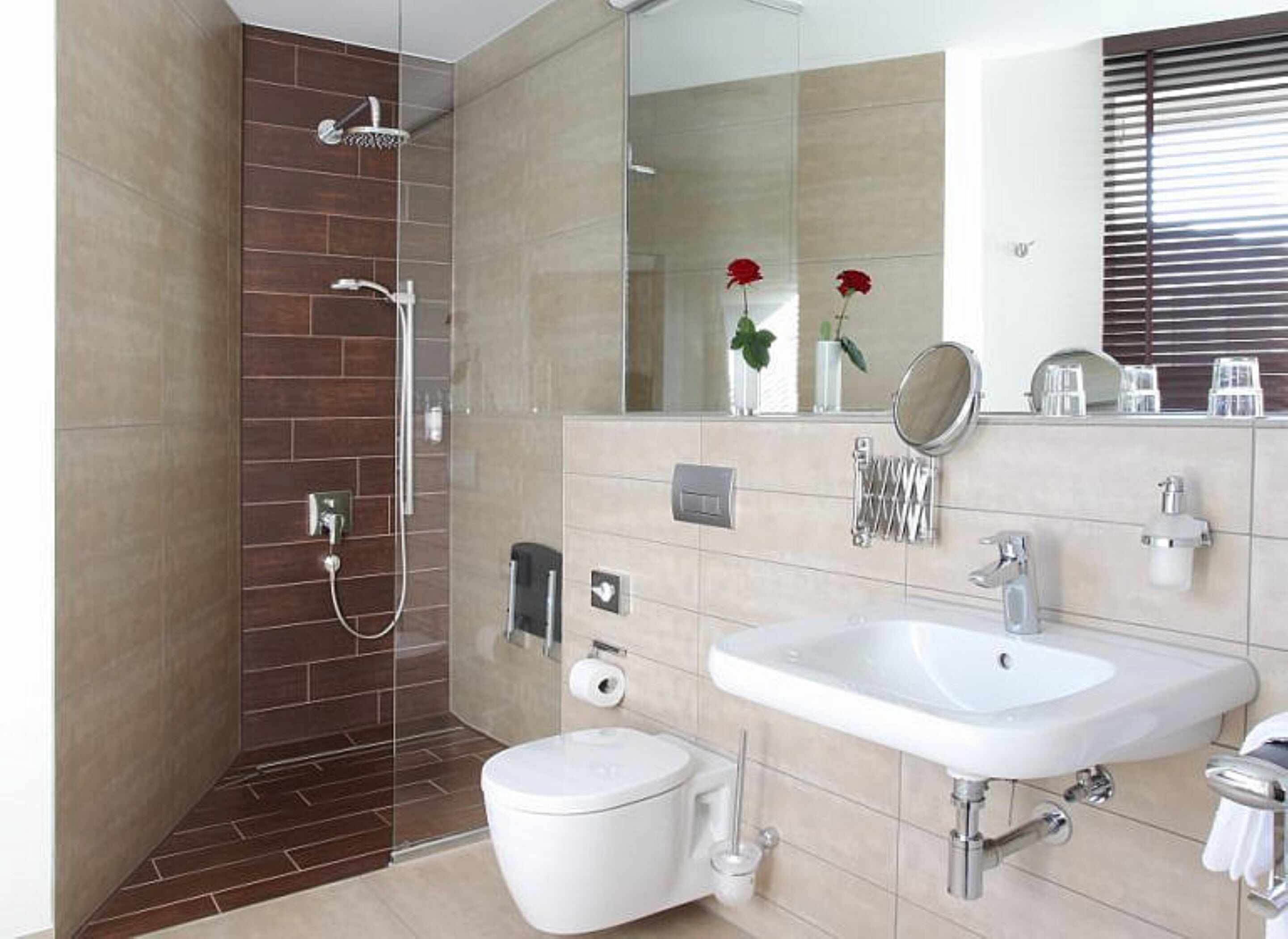 Un baño moderno con ducha, inodoro, lavamanos y un espejo grande.