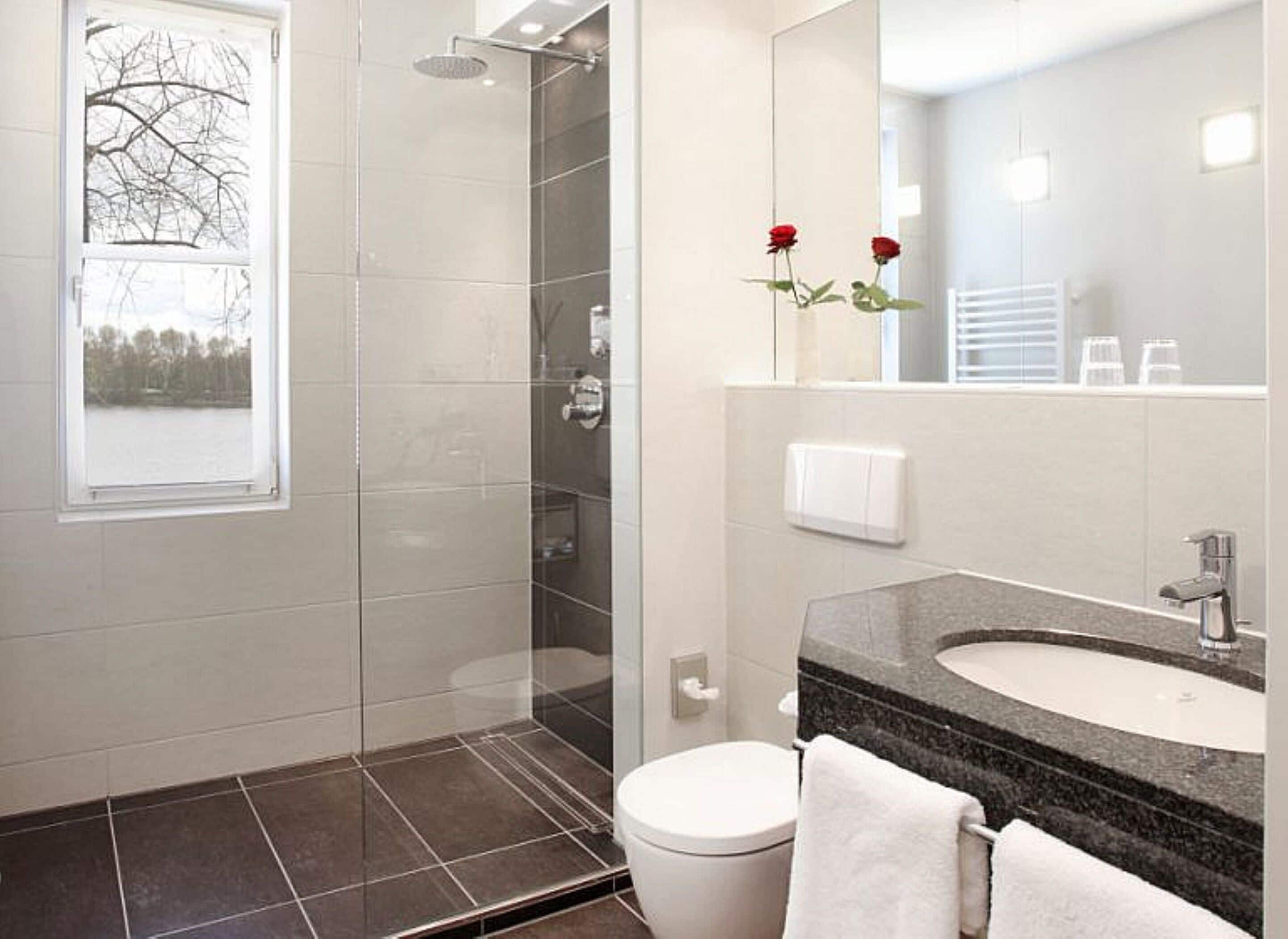 Un baño moderno con ducha, inodoro y lavamanos.