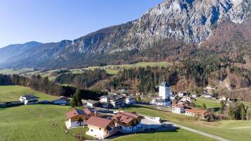 A village with traditional architecture, a prominent church, and a mountain backdrop.
