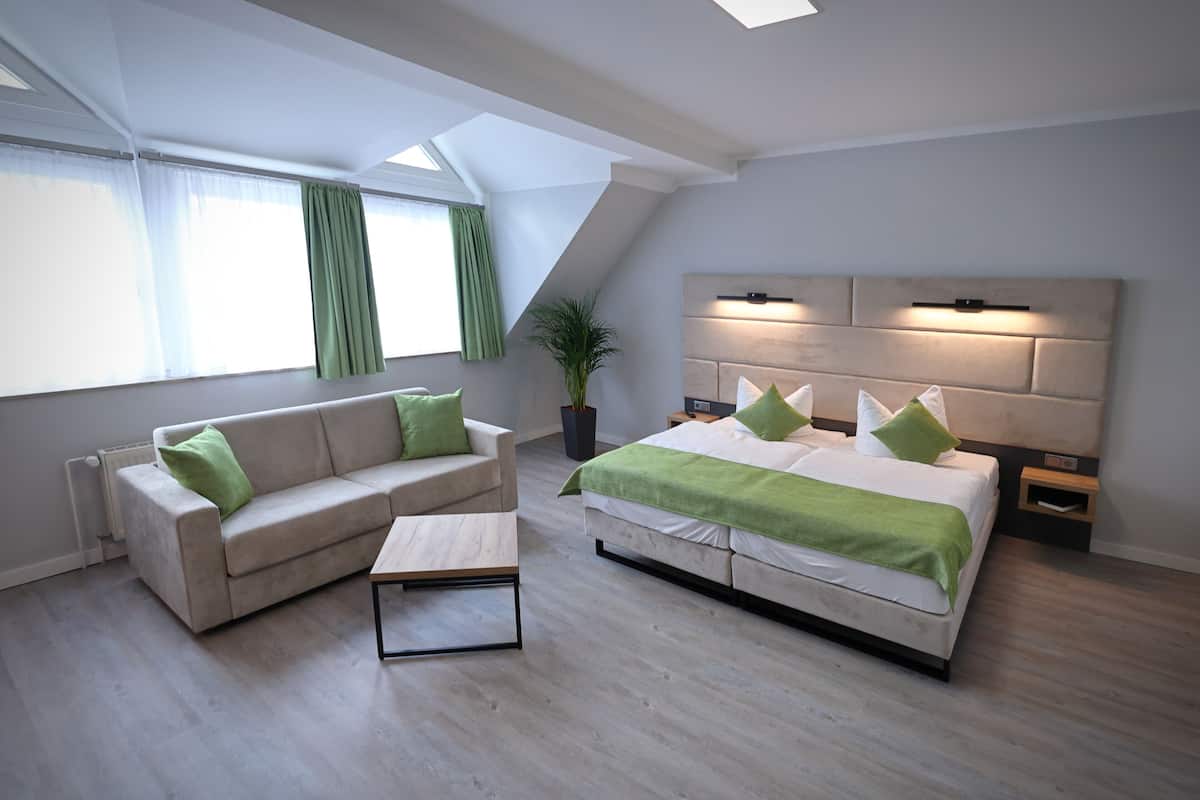 Un dormitorio moderno con una cama, un sofá y una mesita.
